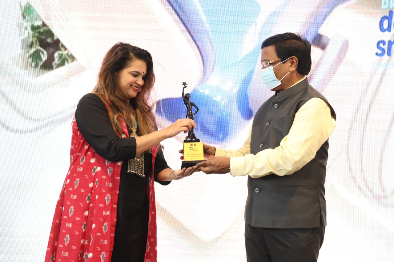Dr. Kavita Bhat Kumar accepting recognition trophy at awards ceremony