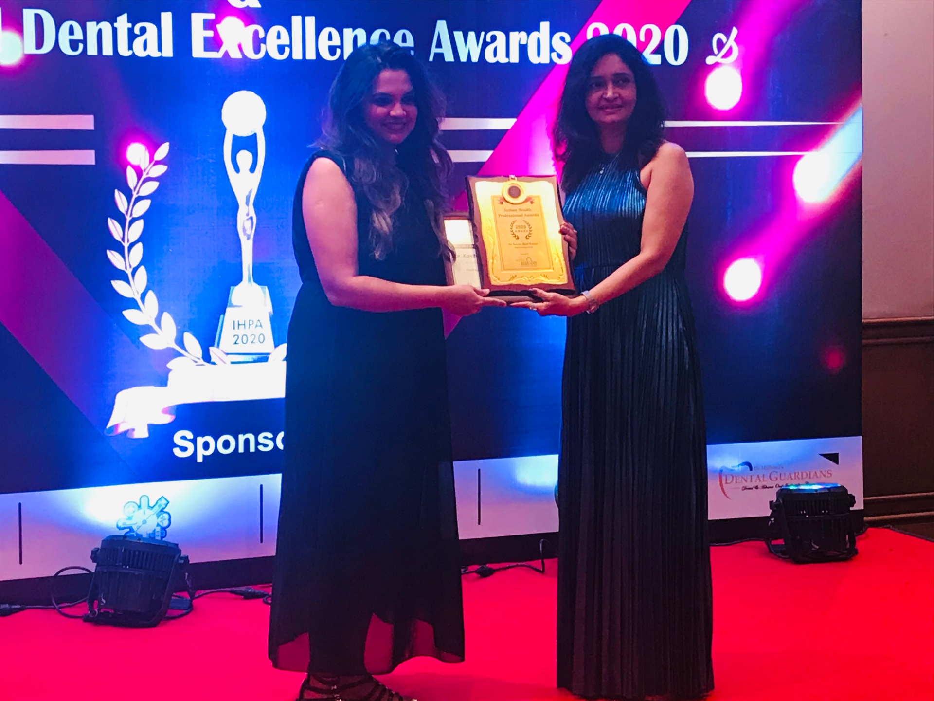 Dr. Kavita Bhat Kumar receiving Dental Excellence Award 2020 on stage Dr. Kavita Bhat Kumar receiving Dental Excellence Award 2020 on stage