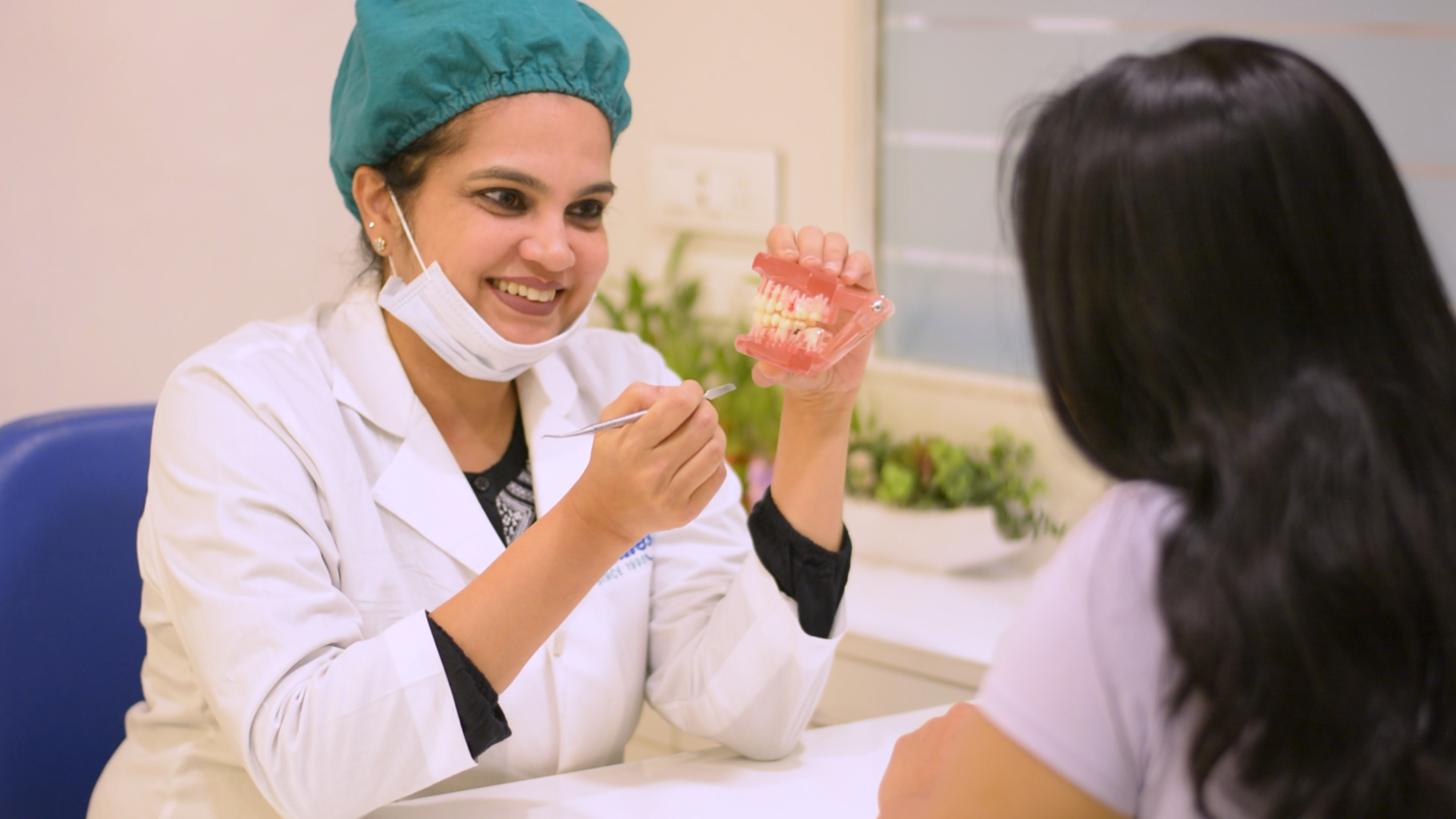 Dr. Kavita explaining a treatment plan to a patient at Designer Smiles Dr. Kavita explaining a treatment plan to a patient at Designer Smiles